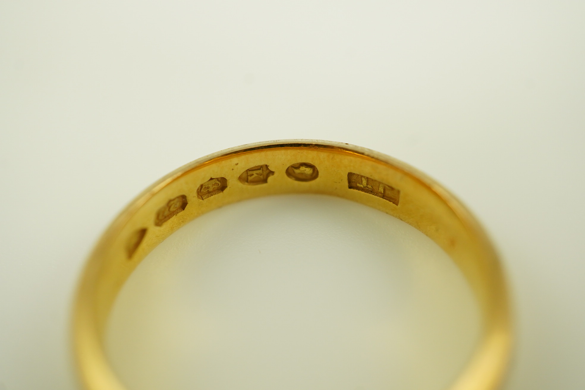 A late Victorian 22ct gold wedding band, London, 1885, size O and a later 22ct gold wedding band